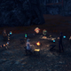 Figures gather around a campfire in dusky light.